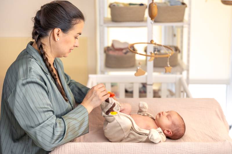 visuel Consultation postnatal, femme qui déshabille un bébé qui dort